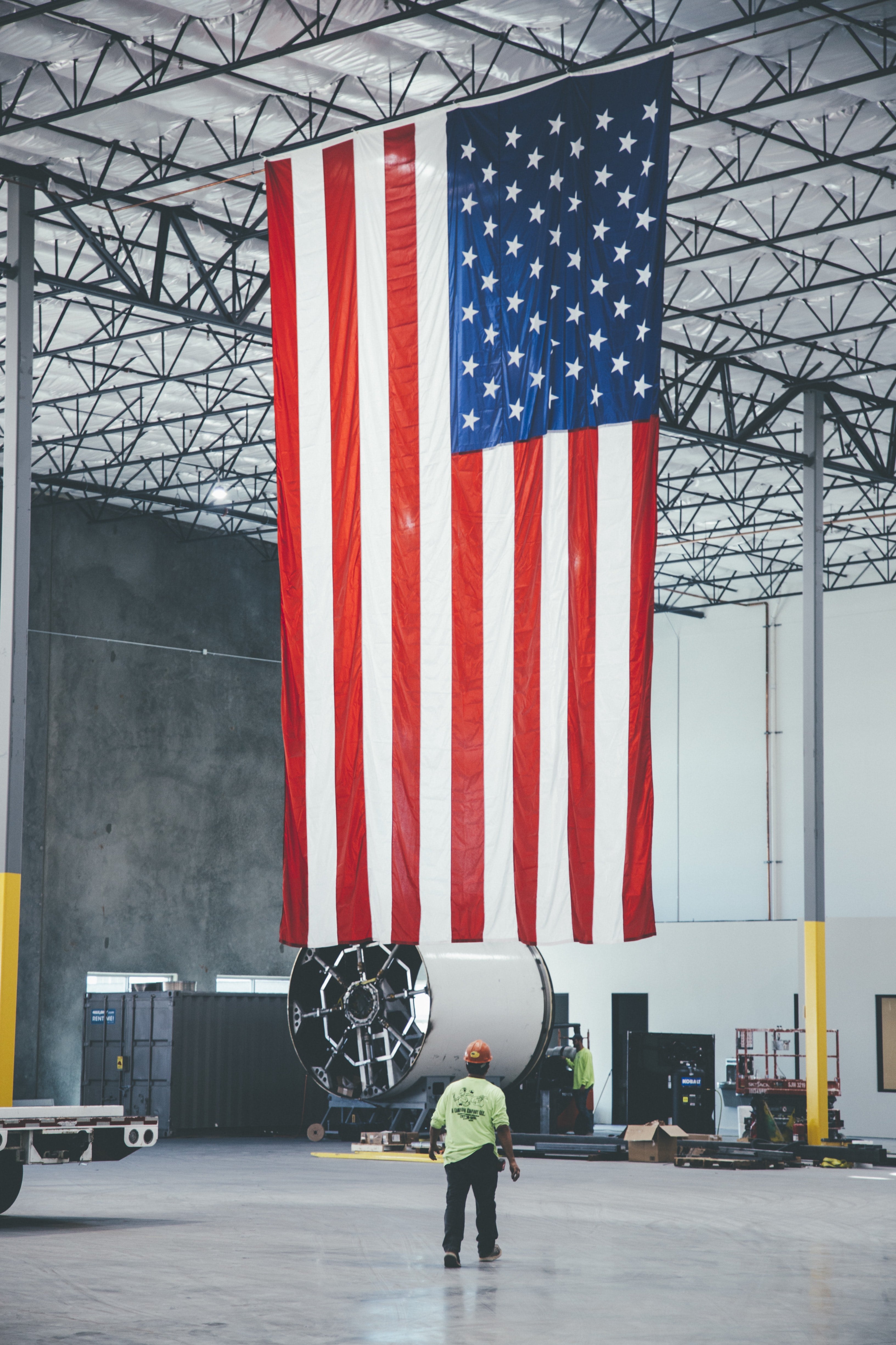 An American flag above workers at the Hyperloop One manufacturing facility